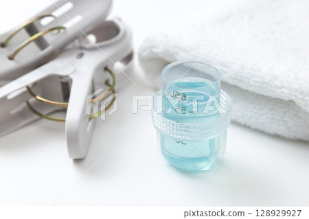 Laundry detergent and towels on white background Laundry detergent and towels on white background 128929927