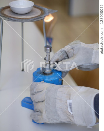 Person is holding a blue object with a white label on it 128930053