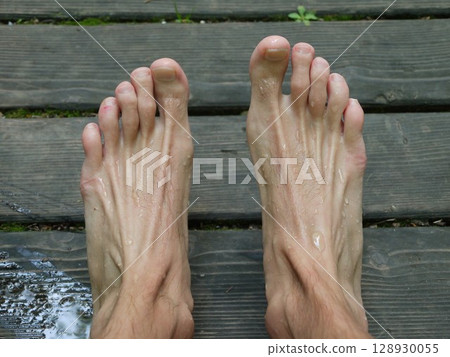 Man's feet with a lot of sweat on them 128930055