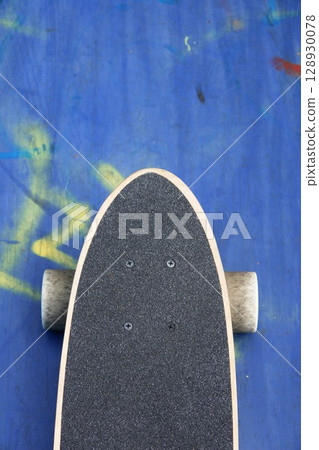 Skateboard with a black grip tape and a yellow stripe on the bottom 128930078