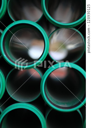 Series of green pipes are shown in a close up 128930125