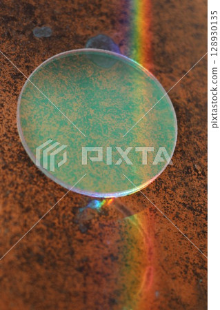 Green circle with a rainbow reflection on it Green circle with a rainbow reflection on it 128930135