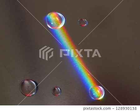 Rainbow is reflected in a puddle of water 128930138