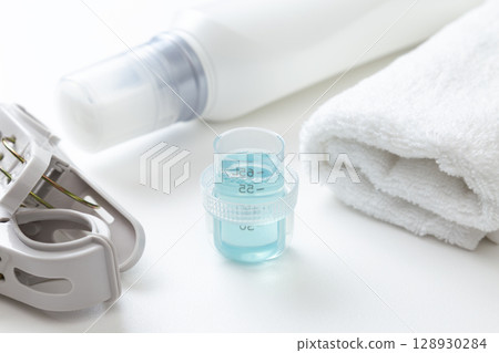 Laundry detergent and towels on white background 128930284