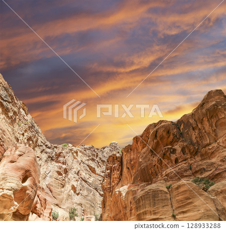 Mountains of Petra (against the background of a beautiful sky with clouds), Jordan, Middle East. Petra has been a UNESCO World Heritage Site since 1985 Mountains of Petra (against the background of a beautiful sky with clouds), Jordan, Middle East. Petra has been a UNESCO World Heritage Site since 1985 128933288