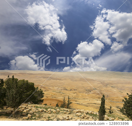 Typical mountain landscape, Jordan, Middle East (photography from a high point). Against the background of a beautiful sky with clouds Typical mountain landscape, Jordan, Middle East (photography from a high point). Against the background of a beautiful sky with clouds 128933896