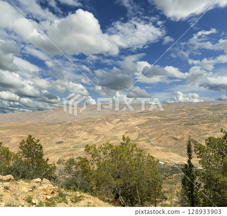 Typical mountain landscape, Jordan, Middle East (photography from a high point). Against the background of a beautiful sky with clouds Typical mountain landscape, Jordan, Middle East (photography from a high point). Against the background of a beautiful sky with clouds 128933903