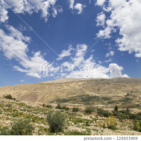 Typical mountain landscape, Jordan, Middle East (photography from a high point). Against the background of a beautiful sky with clouds Typical mountain landscape, Jordan, Middle East (photography from a high point). Against the background of a beautiful sky with clouds 128933909