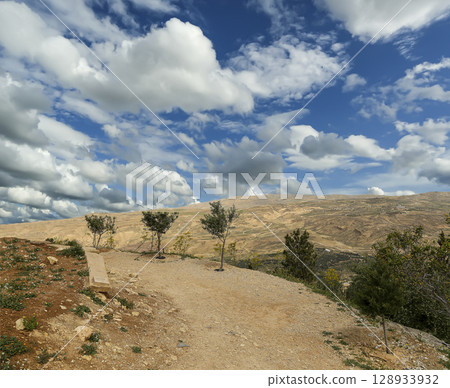 Typical mountain landscape, Jordan, Middle East (photography from a high point). Against the background of a beautiful sky with clouds Typical mountain landscape, Jordan, Middle East (photography from a high point). Against the background of a beautiful sky with clouds 128933932