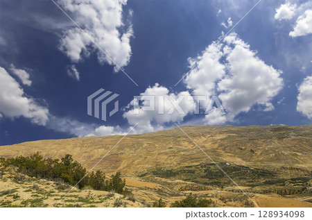 Typical mountain landscape, Jordan, Middle East (photography from a high point). Against the background of a beautiful sky with clouds Typical mountain landscape, Jordan, Middle East (photography from a high point). Against the background of a beautiful sky with clouds 128934098