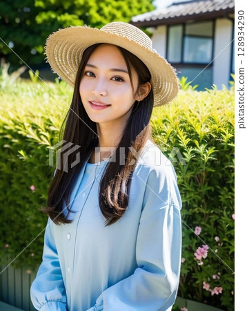 young woman wearing a straw hat 128934290