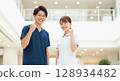 Smiling Asian nurse giving a thumbs up 128934482