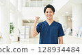 Smiling Asian nurse giving a thumbs up 128934484