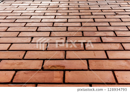 Red brick wall pattern with straight horizontal alignment viewed from a low perspective 128934793