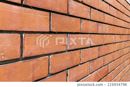 Red brick wall pattern with straight horizontal alignment viewed from a left perspective 128934796