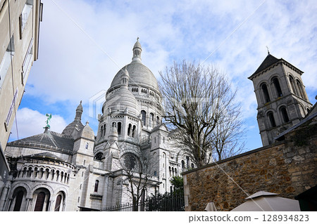 Sacre Coeur basilica between buildings in Montmartre Sacre Coeur basilica between buildings in Montmartre 128934823