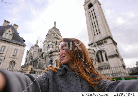 Happy tourist woman taking selfie near Sacre Coeur Basilica Paris 128934871