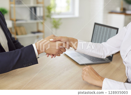 Close-Up Of Business People Shaking Hands During Office Work Close-Up Of Business People Shaking Hands During Office Work 128935003