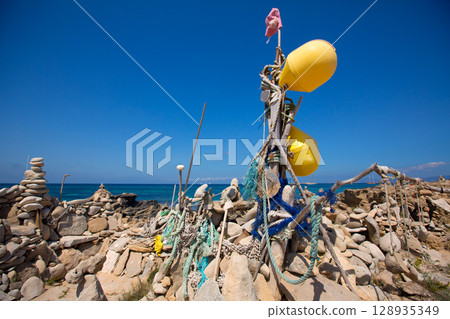 Stone figures on beach shore of Illetes beach in Formentera 128935349