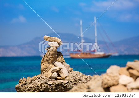Stone figures on beach shore of Illetes beach in Formentera Stone figures on beach shore of Illetes beach in Formentera 128935354