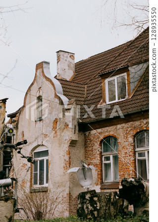 historic house with white and green roofs. house is surrounded by trees and it has lot of leaves. historic house with white and green roofs. house is surrounded by trees and it has lot of leaves. 128935550