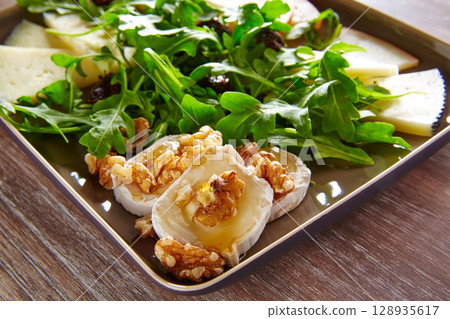 Arugula salad with goat cheese honey and nuts 128935617