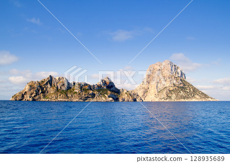Es Vedra islet and Vedranell islands blue sea Es Vedra islet and Vedranell islands blue sea 128935689