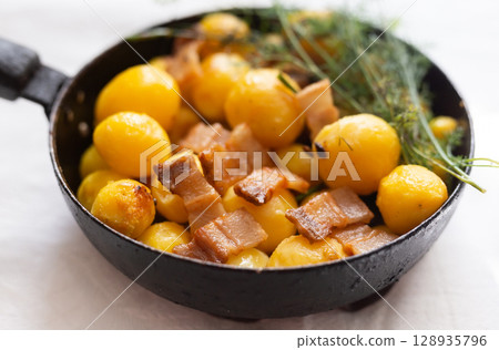 young potatoes with pork belly fried in frying pan young potatoes with pork belly fried in frying pan 128935796