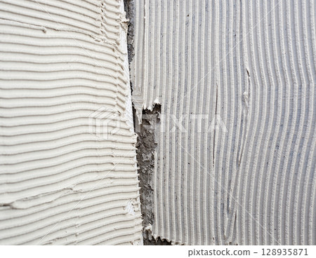 construction notched trowel mortar shape on big tile construction notched trowel mortar shape on big tile 128935871