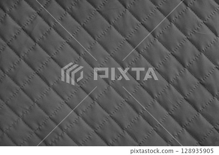 Checkered, diamond stitching pattern, black quilted fabric background. Blanket stitch texture Checkered, diamond stitching pattern, black quilted fabric background. Blanket stitch texture 128935905