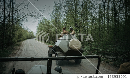 Soldiers on Armored Vehicle Along Scenic Forest Path 128935991