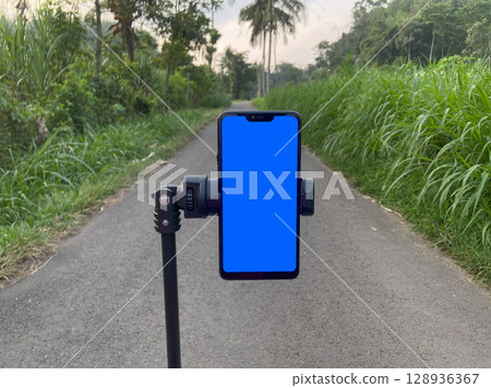 Smart phone with blue screen on the road in the countryside of Indonesia 128936367
