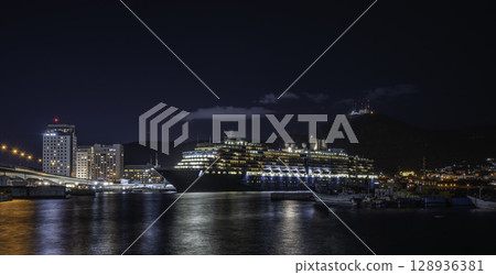 Luxury cruise ship anchored at a pier at night 128936381