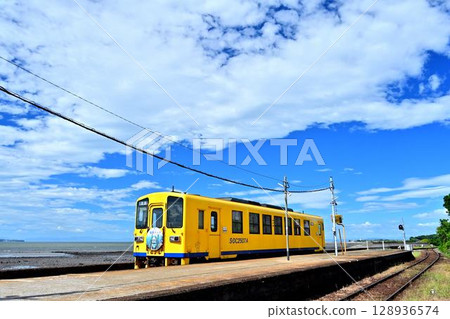 The yellow train at Furube Station on the Shimabara Railway runs along the coastline. The yellow train at Furube Station on the Shimabara Railway runs along the coastline. 128936574