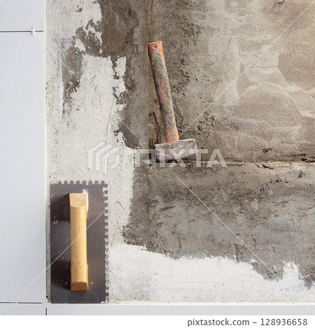 construction tools notched trowel and hammer 128936658
