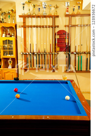 Billiard club with blue pool table cue and trophy 128936672