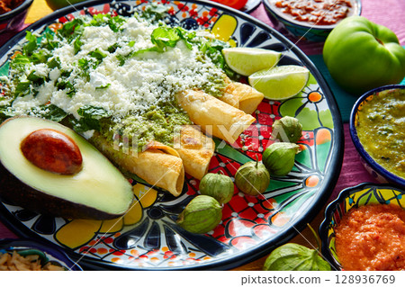 Green enchiladas Mexican food with guacamole 128936769