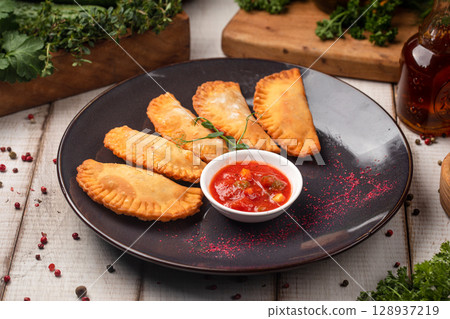 Fried empanadas served with spicy tomato dip Fried empanadas served with spicy tomato dip 128937219