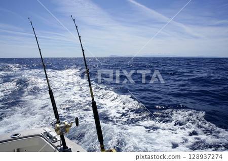 Fishing on the boat with trolling rod and reel. Fishing on the boat with trolling rod and reel. 128937274