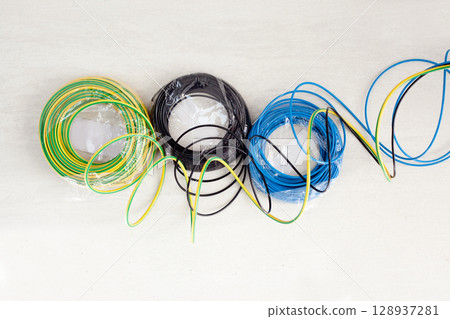 Electric cable coil in three colors black blue and earth Electric cable coil in three colors black blue and earth 128937281