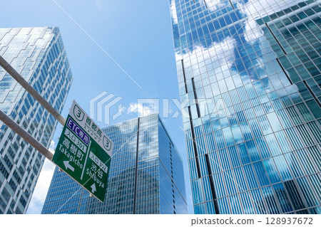 A view of an office district looking up at road signs and skyscrapers 128937672