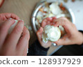 two child's hands cutting vegetables for salad close up 128937929