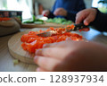 two child's hands cutting vegetables for salad close up 128937934