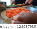 two child's hands cutting vegetables for salad close up 128937935