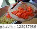 two child's hands cutting vegetables for salad close up 128937936