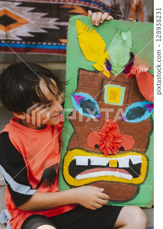 Boy Proudly Displays Colorful Handmade Mask 128938231