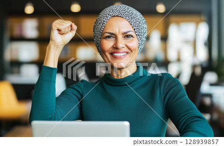 Muslim middle eastern woman in office with raised fist of empowerment, strength and women solidarity, International Womens Day concept 128939857