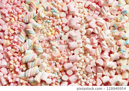 Confectionery and sweeties varieties background: light pink and white marshmallows, sugar confetti, bonbon and candies, selective focus 128940954