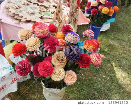 Multicolored rose flowers, carved by a craftsman from wood 128941250