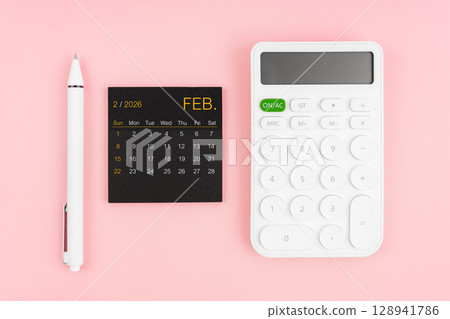 February 2026 calendar and white calculator with pen on pink color background. February 2026 calendar and white calculator with pen on pink color background. 128941786